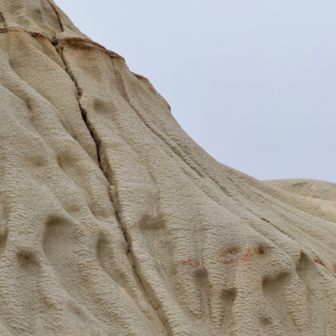 This ancient dune, pressed into rock, is now crumbling away.
